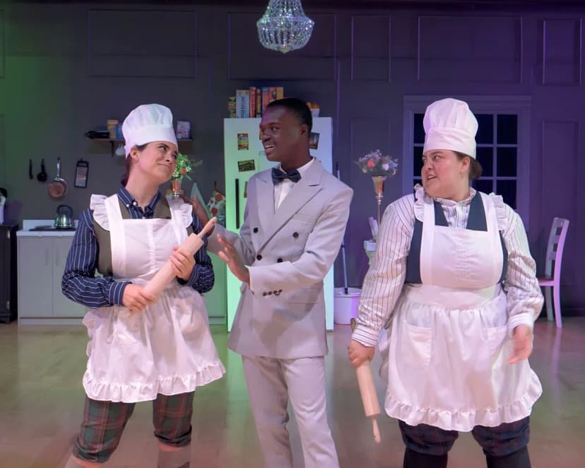 3 students in customs on stage, moment from a Drowsy Chaperone show