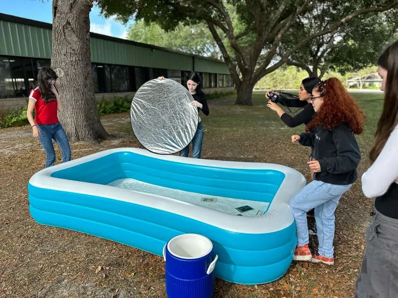 Students working outside with lighting equipment