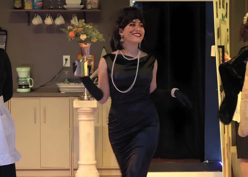 a female Student on stage wearing luxury clothing from the 80ties