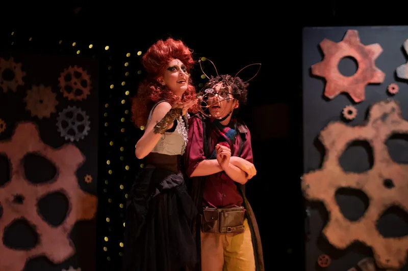 2 students in the middle of theatre performance on the stage