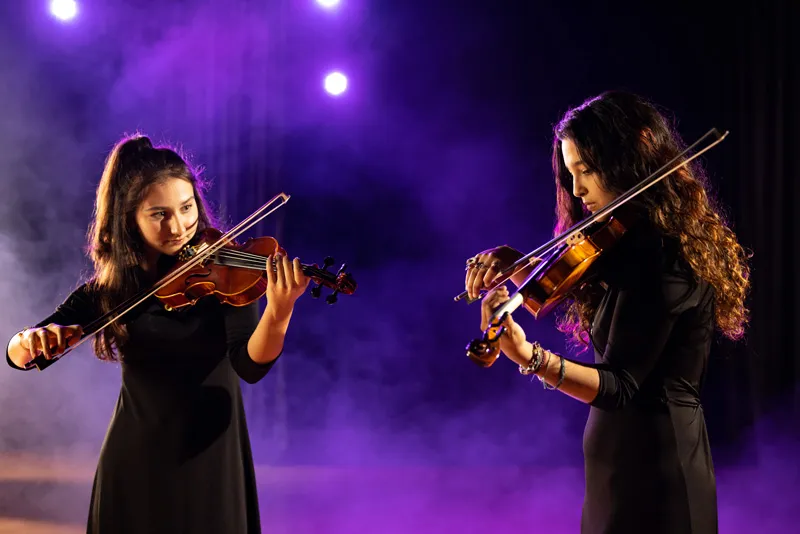 Two students playing violins